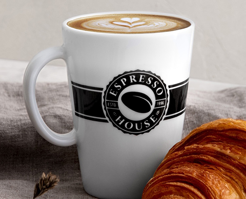 Espresso house kopp med kaffe  og en croissant