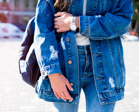 Bilde av en jente med olajakke og jeans. 